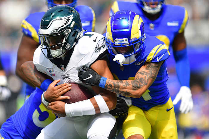 Philadelphia Eagles quarterback Jalen Hurts (1) runs the ball against Los Angeles Rams linebacker Ernest Jones (53) and cornerback Ahkello Witherspoon (44) during the first half at SoFi Stadium.